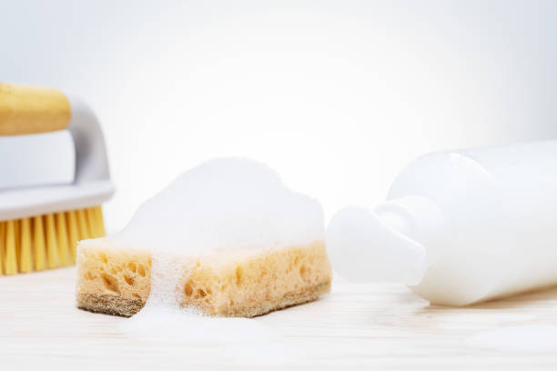 istock Eco cleaning products. Sponge, brush with soapy foam on tile surface. 1400425794