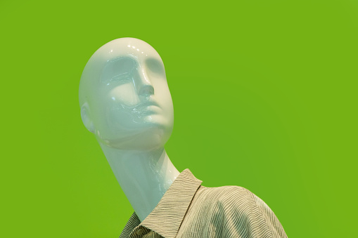 Head and shoulder of mannequin against green background