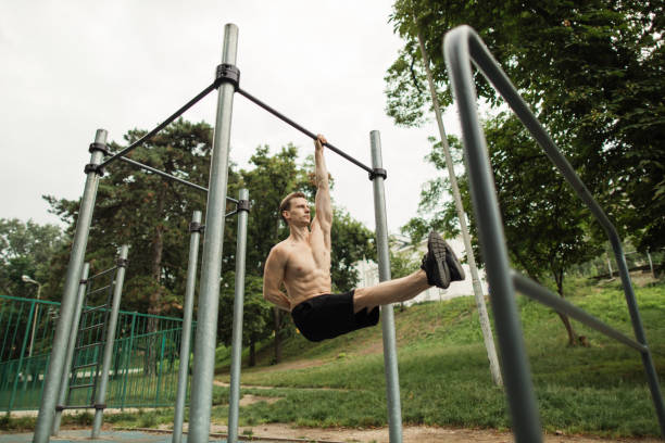 istock Young caucasian athlete with muscular torso doing corner on crossbar 1400427885