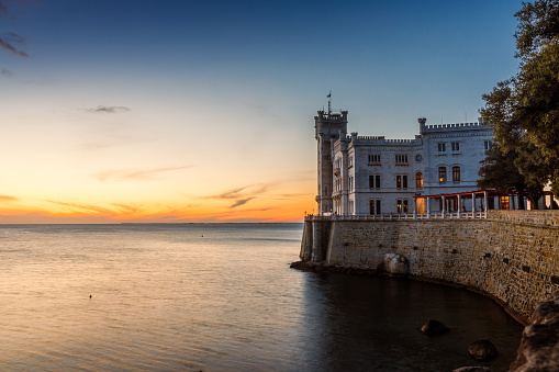 Miramare, Trieste, Italy - November 10, 2019: The White Marble Stone Castle of Miramare at Sunset