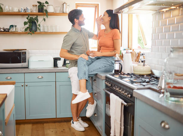 istock Young cheerful interracial couple bonding while drinking tea together at home. Loving caucasian boyfriend and mixed race girlfriend standing in the kitchen. Content husband and wife relaxing and spending time together in the morning 1400435790