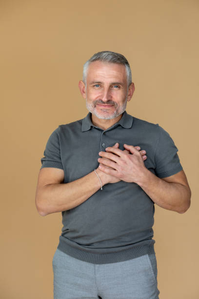 A man putting his hands on his chest to his heart stock photo