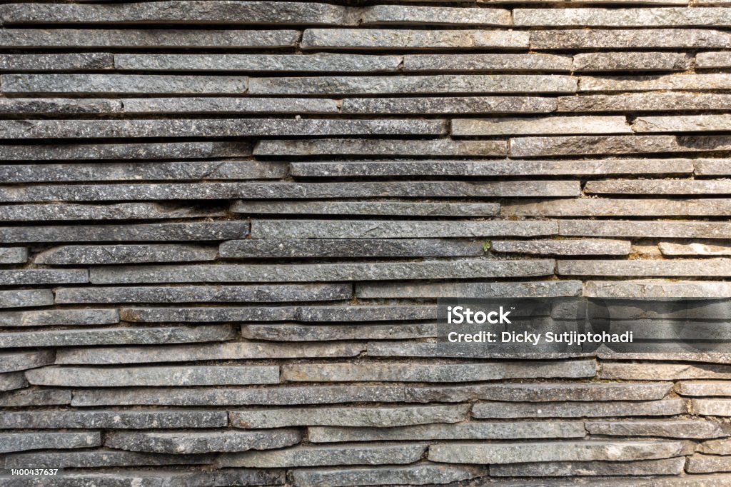 A Horizontal Stack of Thin Plates of Rocks A pile of small and thin rock plates stacked together to form a simulation of natural decoration for an outdoor wall. Abstract Stock Photo