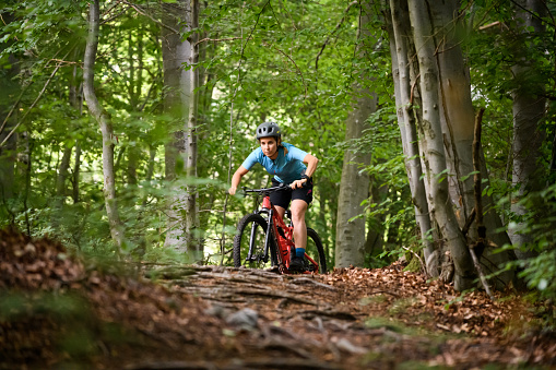Young woman with mountain bike on Italian mountains: Downhill in the forest
