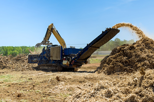 A hydraulic crane loading for shredding machine in roots wood chopped wooding material