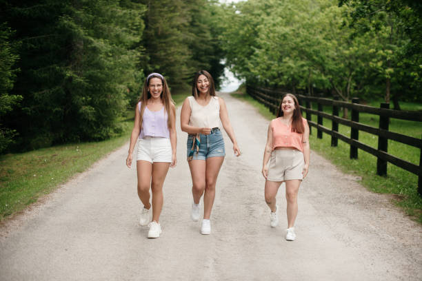 istock Three young women walking on a forest road 1400438676