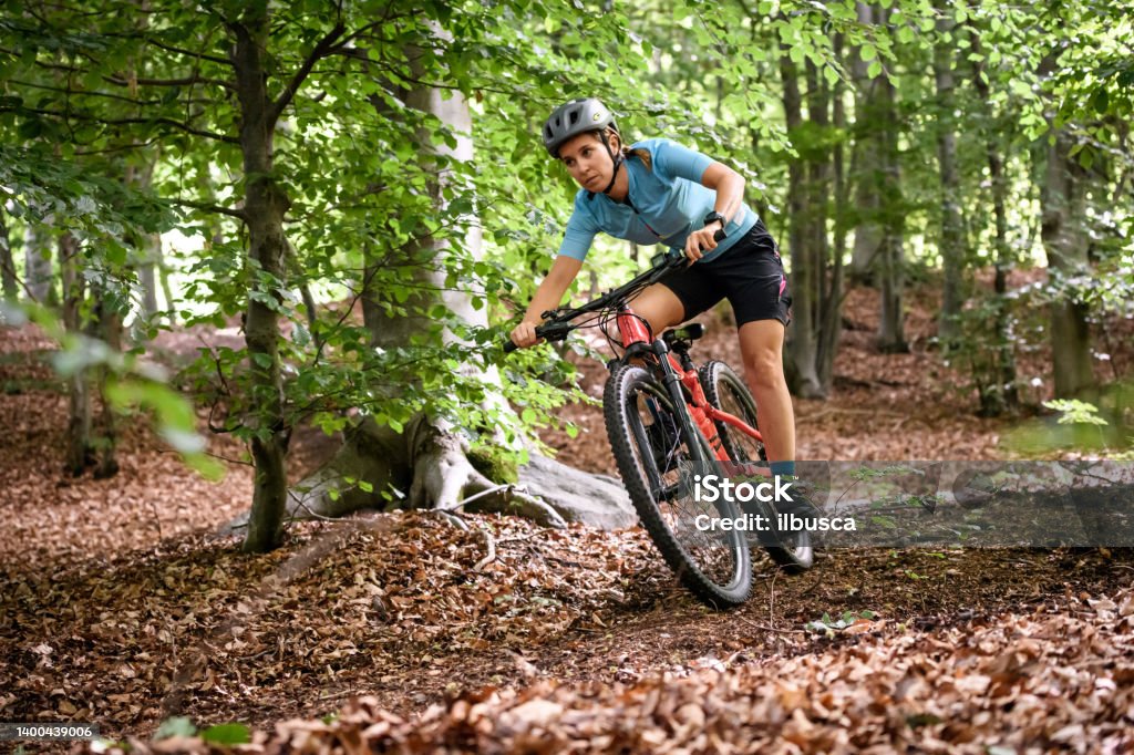 Young woman with mountain bike on Italian mountains: Downhill in the forest Cycling Stock Photo