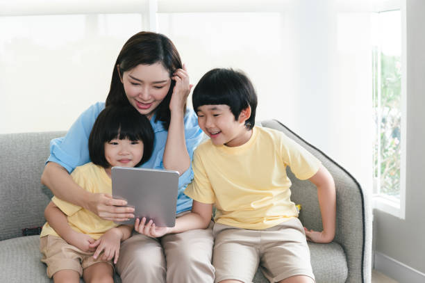 istock Happy Asia mother use tablet with sons at home 1400439204