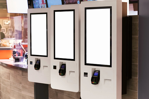 Blank screens for ordering food at the entrance to a fast food restaurant.