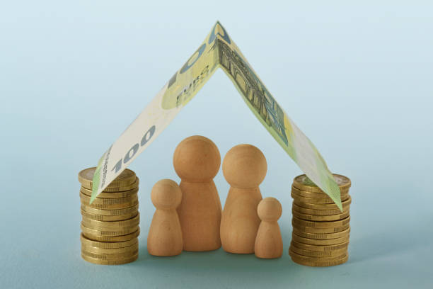 Family under house made of money - Concept of family, home and financial protection stock photo