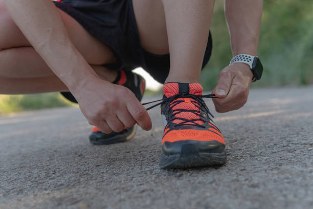 istock Male runner kneeling to tie shoelaces. 1400443825