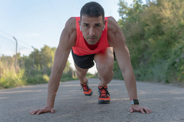 istock Runner man standing on asphalt in race start position. 1400443826