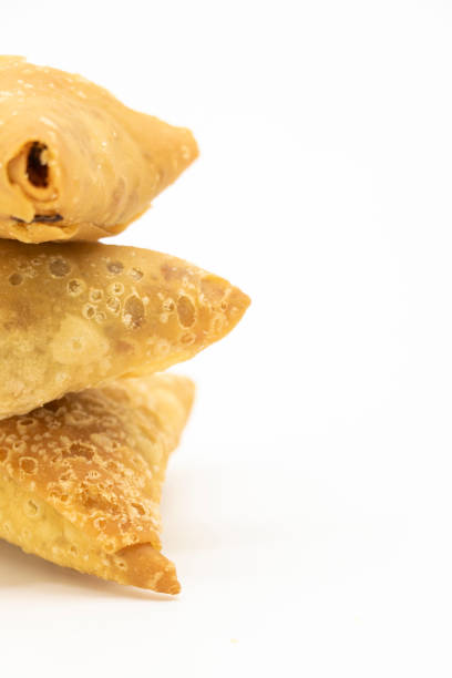 istock three pieces golden samosa isolated on white background. 1400443841