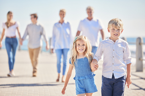 Grandparents, parents or children holding hands at beach as a big family for holiday vacation travel together. Grandfather, grandmother or back of mom walking with dad, love or kids at sea to relax