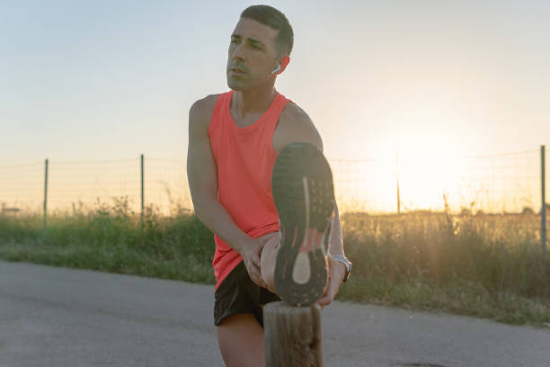 istock Young runner man relaxing one leg on a wooden post. 1400444603