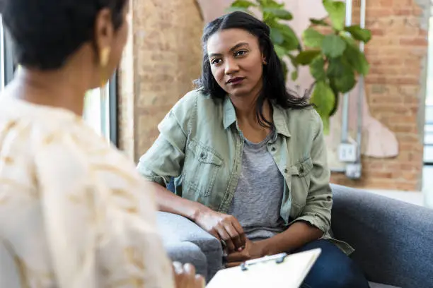 Photo of Young woman focuses on female counselor's advice