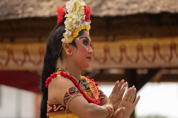 Bali, Indonesia - 28 Aug. 2019: A woman dressed in traditional costume, performs ancient Balinese dance tradition, that is part of the religious and artistic expression among the Balinese people