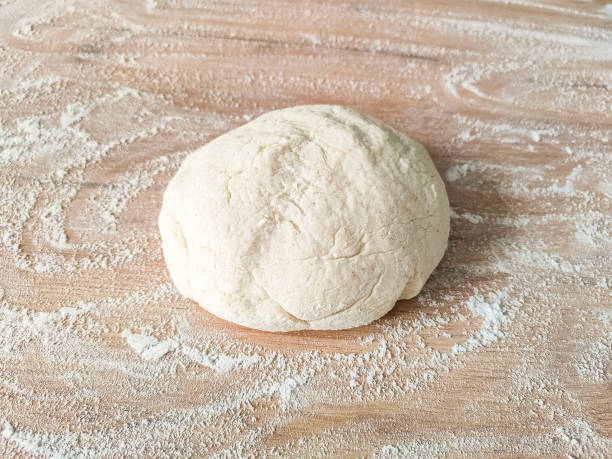 istock Fresh raw dough on wooden table covered with flour. Top view 1400446392