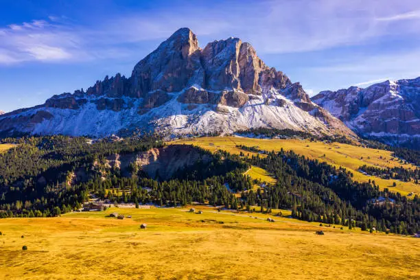 Stunning view of Peitlerkofel mountain from Passo delle Erbe in Dolomites, Italy. View of Sass de Putia (Peitlerkofel) at Passo delle Erbe, with wooden farm houses, Dolomites, South Tyrol, Italy.