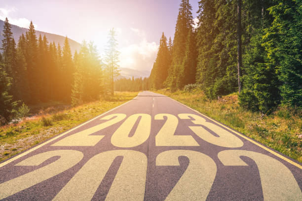 carretera asfaltada vacía y concepto año nuevo 2023. conducir por una carretera vacía en las montañas hasta el próximo 2023 y dejar atrás el viejo 2022. concepto de éxito y paso del tiempo. - the end fotografías e imágenes de stock
