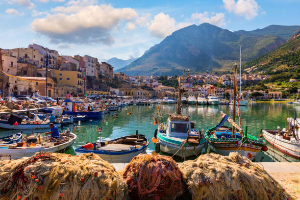 porto siciliano com barcos de pesca da aldeia castellammare del golfo da sicília, trapani, itália. castellammare del golfo (golfo de castellammare) no mar mediterrâneo, trapania, sicília, itália. - trapani - fotografias e filmes do acervo