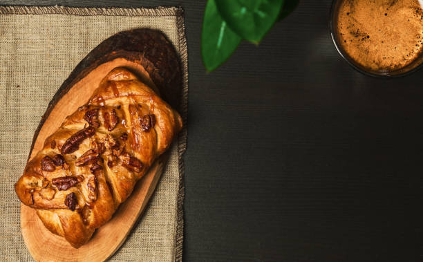 istock Espresso coffee braided with pecans and maple syrup on a dark table. Sweet pastries for breakfast at the hotel. View from above 1400451729