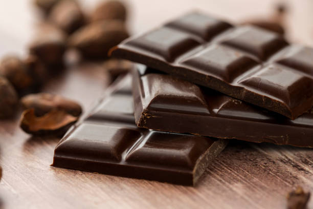 tavoletta di cioccolato fondente con fave di cacao - cioccolato fondente foto e immagini stock