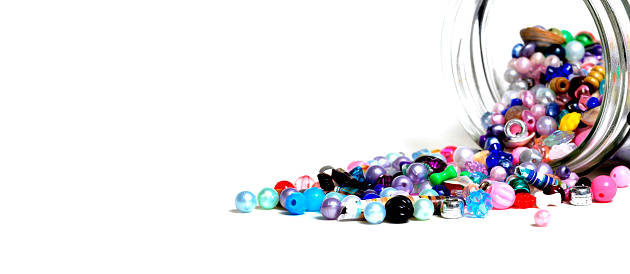 Beads in glass jars for creating art hobbies jewelry on white background