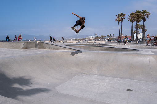 Los Angeles, USA - May 8th, 2022: A skateboarder ripping at the iconic Venice Beach Skatepark late in the day.