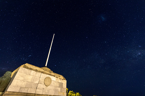This 28 November 2021 long-exposure image shows the Centennial Memorial in Ōtepoti Dunedin, Aotearoa New Zealand. The memorial overlooks the city from Signal Hill reserve. In this late-night image, the memorial is illuminated by a combination of nearby street lights from the back and distant city lights from the front. Five frames were stacked to generate a sharp image of the memorial. The fifth frame was also used for the starry sky. The entire composite image is faithful to the time and location the subject was photographed.