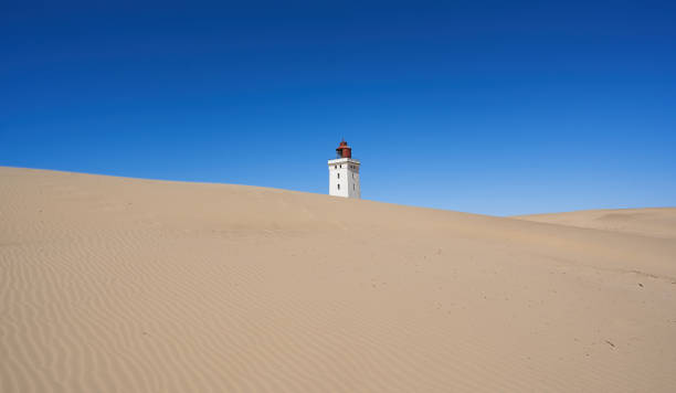 Low angle view of Rubjerg Knude lighthouse on sandy hill stock photo