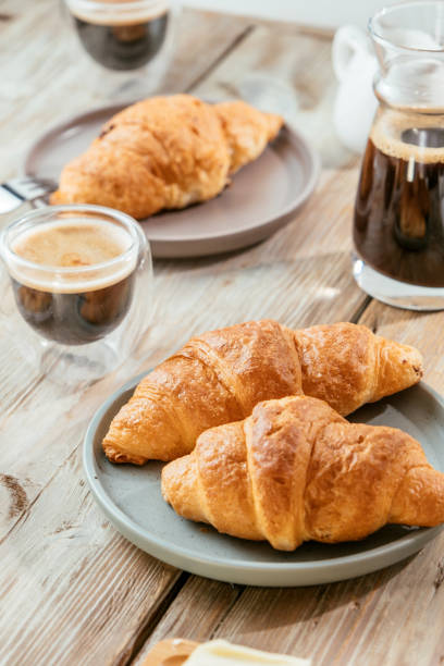 istock Croissants served with coffee on wooden table 1400455922