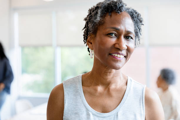 Adult woman has a close up photo taken The new team member has her close up photo taken for the employee of the month board in the break room. 60 69 years stock pictures, royalty-free photos & images