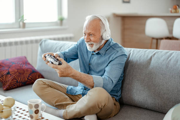 istock Senior Man With Headphones Playing on Console at Home 1400460192
