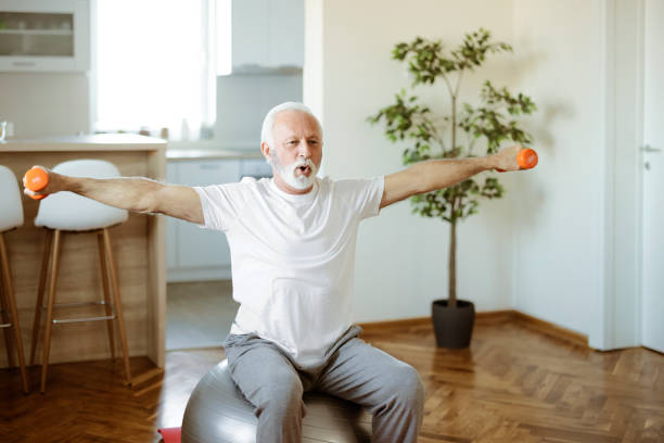 istock Senior Man Doing Exercises with Dumbbells at Home 1400460971