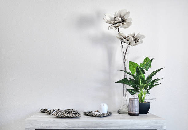 istock Flowers and cute home accessories on table over white wall background 1400461224