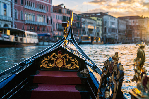 A gondolier paddles towards the sunset in Venice's Grand Canal. Photo taken from the famous Rialto Bridge