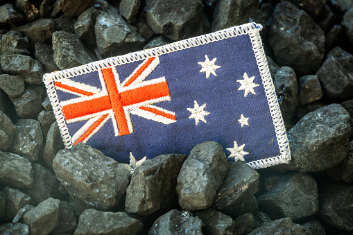 Australian flag on the background of coal, Concept of Coal Mining and Extraction in Australia, Rising commodity prices in the world, Environmental impact, Industry and the economy of the country