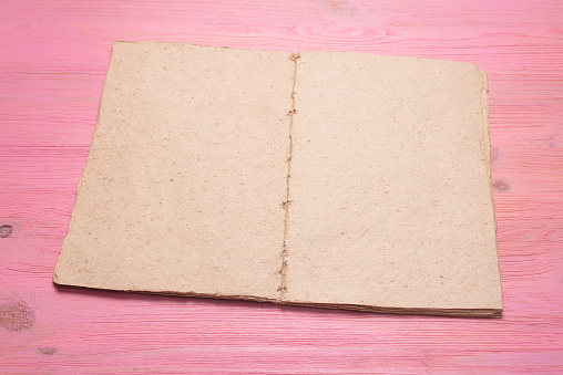 Open blank page book with copy space on the pink flat lay background.