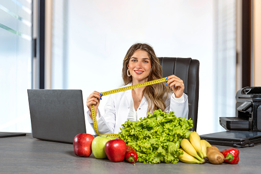 Female dietitian sitting at her desk in her office with healthy food