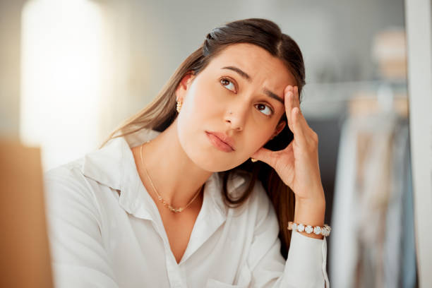 One anxious young hispanic business woman looking bored and worried while working in an office. Entrepreneur with headache feeling overworked, tired and anxious about deadlines. Mentally frustrated with burnout and stress una joven empresaria hispana ansiosa que parecía aburrida y preocupada mientras trabajaba en una oficina. emprendedor con dolor de cabeza sintiéndose sobrecargado de trabajo, cansado y ansioso por los plazos. mentalmente frustrado con el agotamiento y el