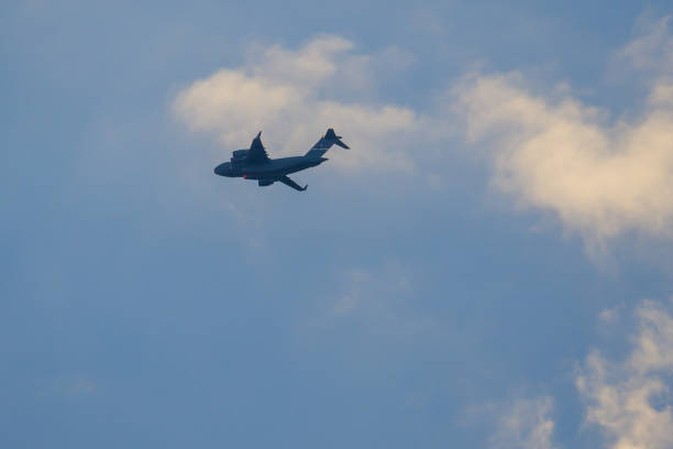 Jet fighter aircrafts escorting a C-17 Globemaster III, F-15B Eagle, US Air Force. USAF Boeing McDonnell Douglas C-17 jet transport airlifter.