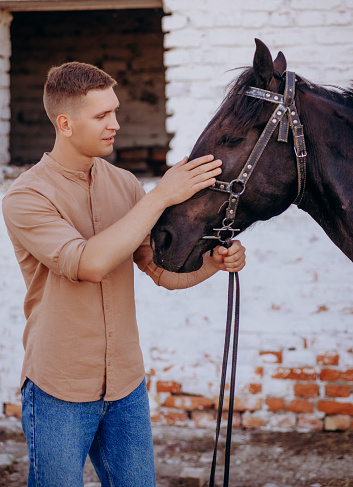 Young man petting a horse. Loving tender moment between men and horse.