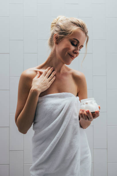istock Blonde Woman Applying Lotion After A Shower 1400481167