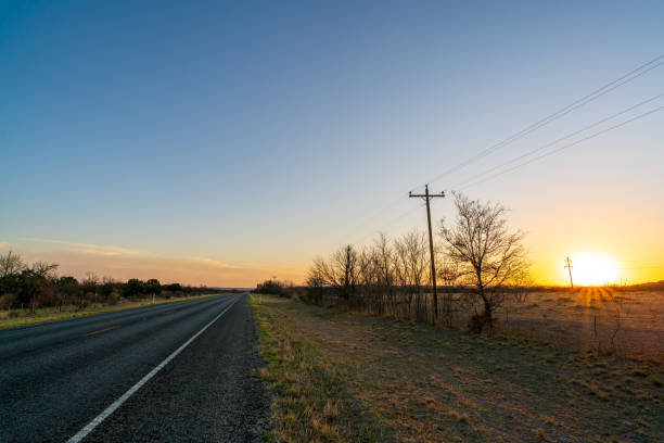 blick auf die zweispurige landstraße in texas mit sonnenuntergang auf der rechten seite - empty nobody two lane highway highway stock-fotos und bilder