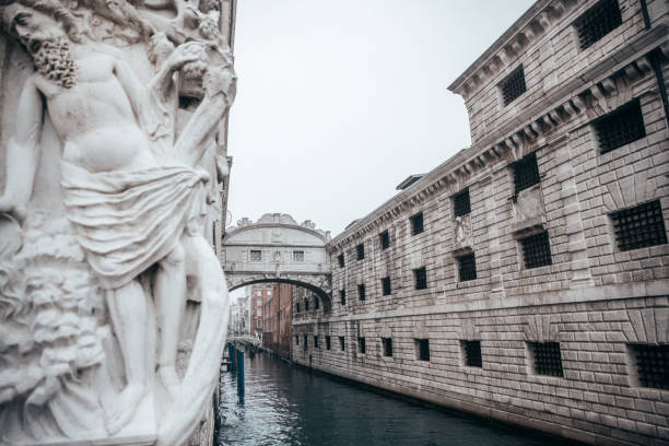 Historic Bridge of Sighs connecting the Doge's Palace with the New Prison in Venice, Italy, with canal and traditional sculpture