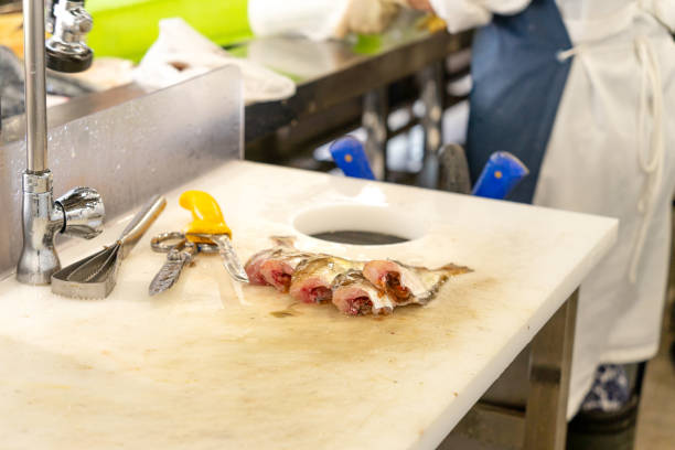 Fresh fish cut and cleaned on a fishmonger's table. Utensils to cut the fish and clean it. stock photo