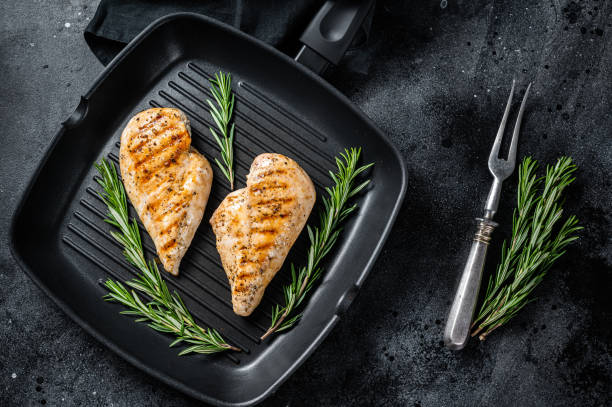 istock Grilled healthy chicken breasts cooked on a grill pan. Black background. Top view 1400486720