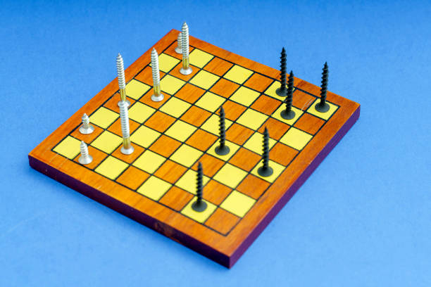 Dark and light screws stand on the chessboard like pieces.