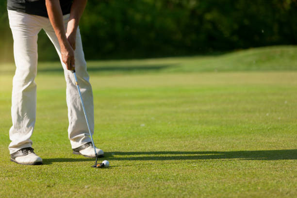 istock Golfer holding club and hitting ball 1400487575